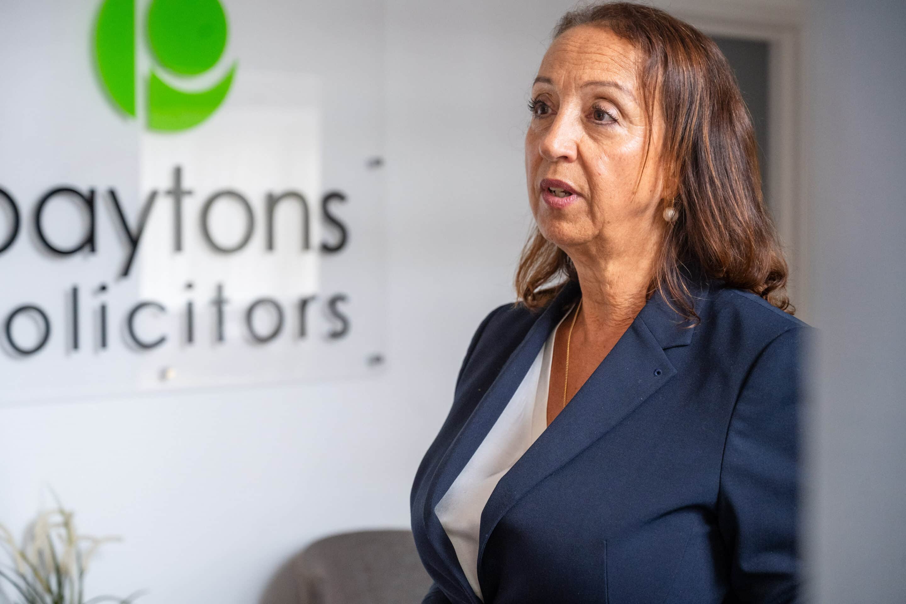 A person stood in from of Payton Solicitors office sign